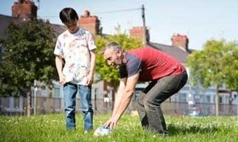 Young boy and foster carer playing football