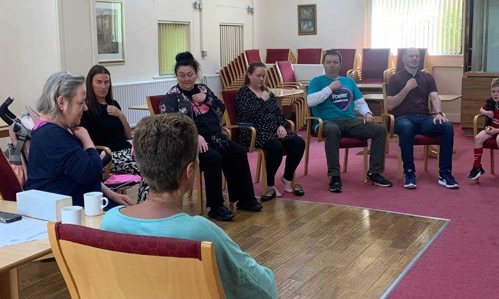 Fostering community taking part in group activity, holding clenched fist to chest