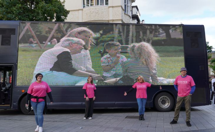 Foster 4 team in front of a digital ad bus
