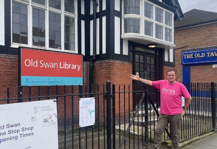 Foster carer Phil pointing at Old Swan Library entrance