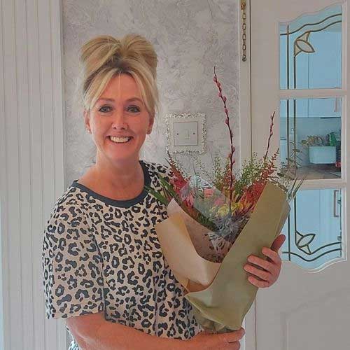 Foster carer Vicky holding bouquet of flowers