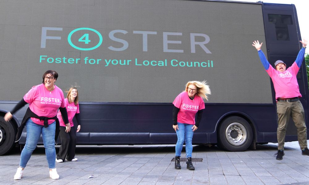 Foster 4 team jumping in front of the roadshow bus