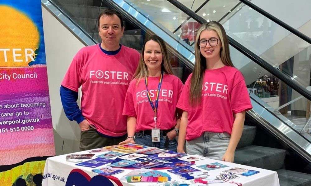 Members of the Fostering Liverpool team wearing matching foster 4 t-shirts at a pop-up event